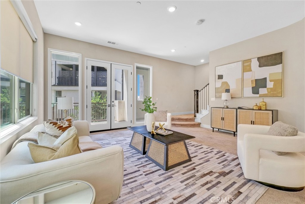 a living room with furniture and floor to ceiling windows