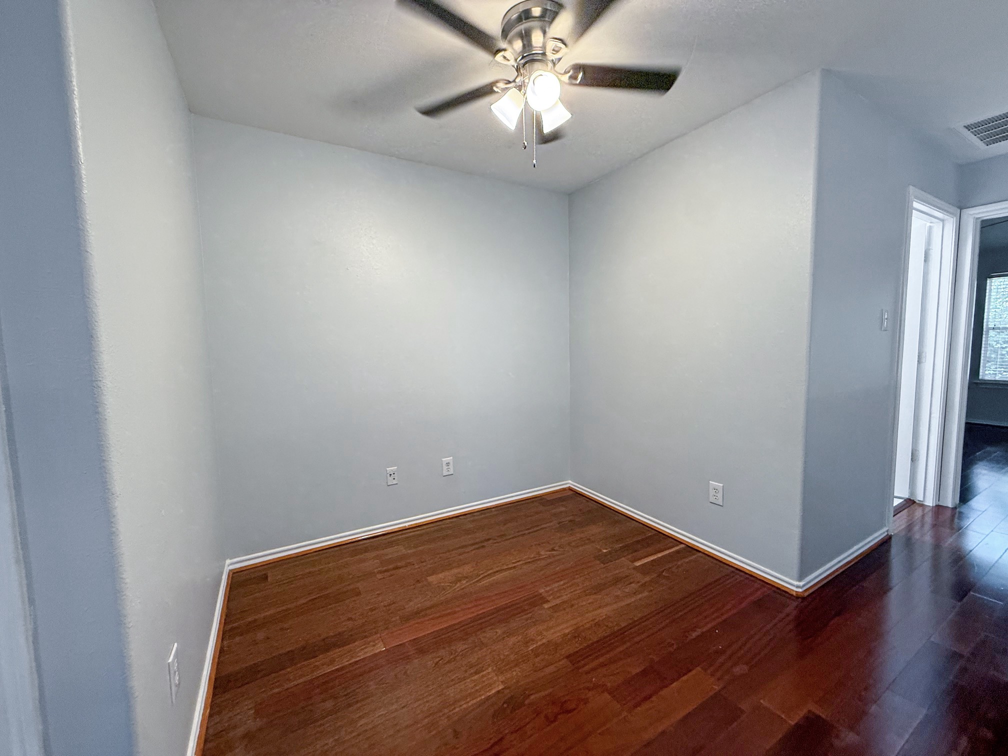 3 Peach Ridge Place The Woodlands, TX 77382 - Photo 11 of 22 an empty room with wooden floor and fan