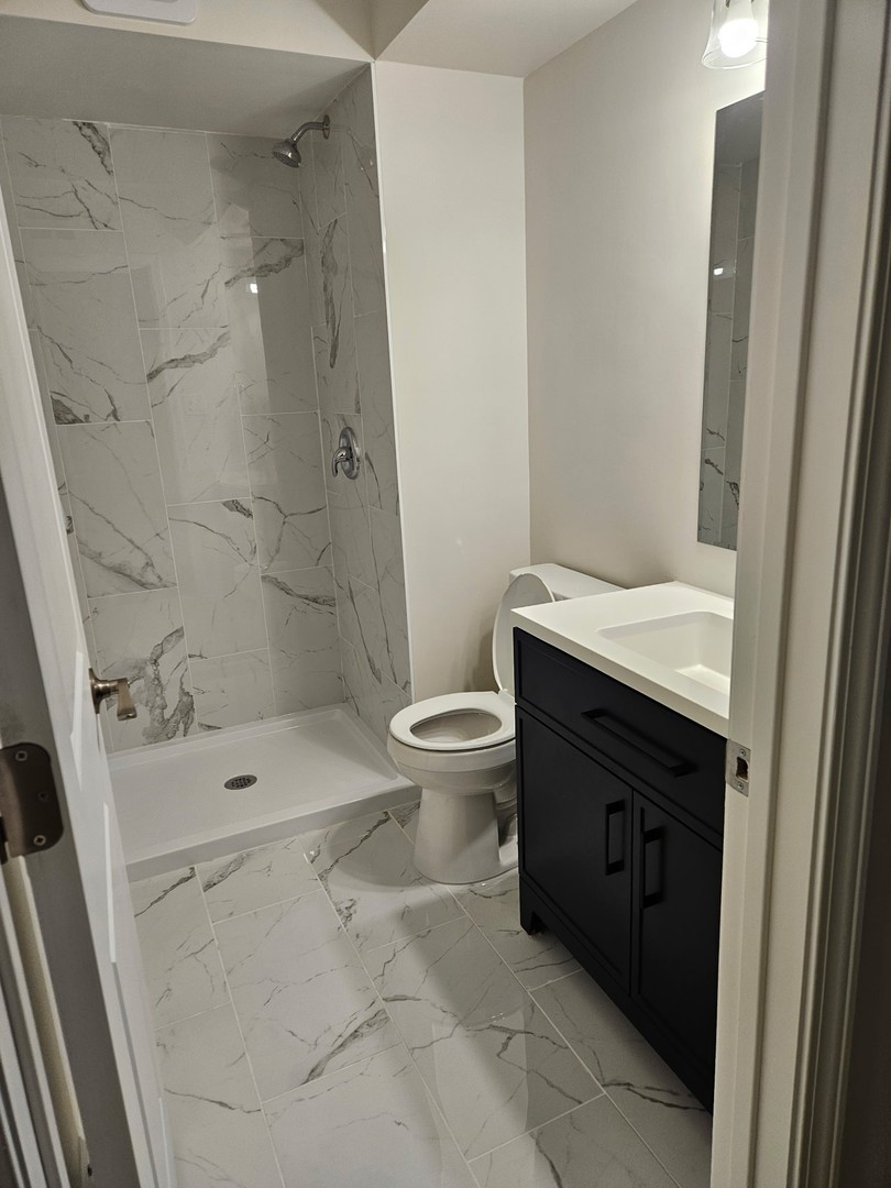 14969 South Willowcrest Drive, Unit 17 Midlothian, IL 60445 - Photo 12 of 12 a bathroom with a sink a toilet a mirror and shower