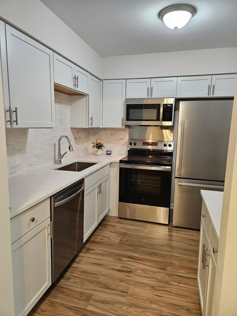 14969 South Willowcrest Drive, Unit 17 Midlothian, IL 60445 - Photo 5 of 12 a kitchen with stainless steel appliances a refrigerator sink and stove