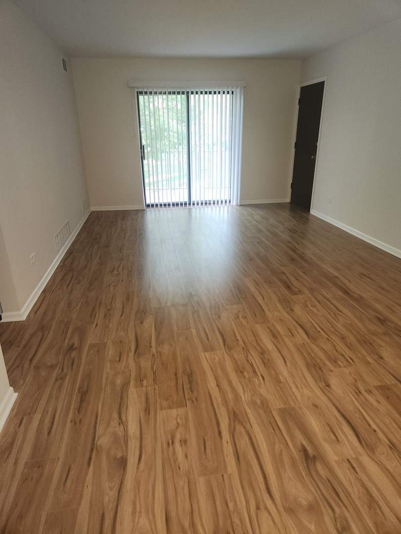 14969 South Willowcrest Drive, Unit 17 Midlothian, IL 60445 - Photo 7 of 12 wooden floor in an empty room with a window