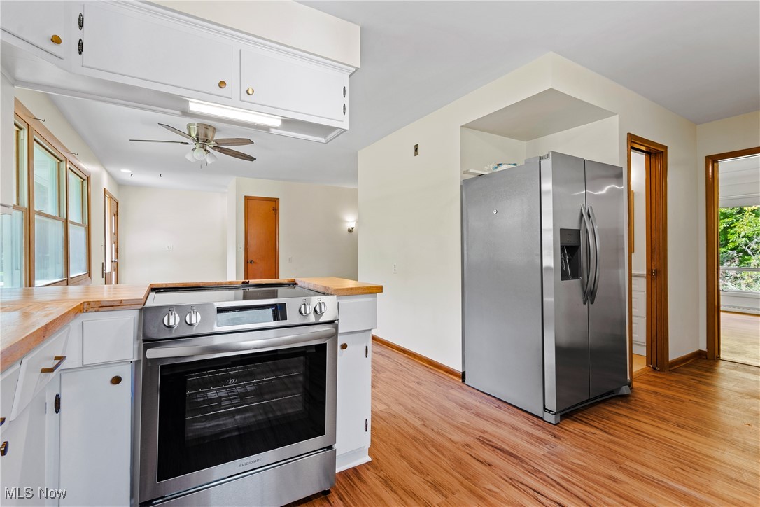 870 Trebisky Road Cleveland, OH 44121 - Photo 14 of 48 Kitchen with appliances with stainless steel finishes, white cabinetry, and light hardwood / wood-style floors