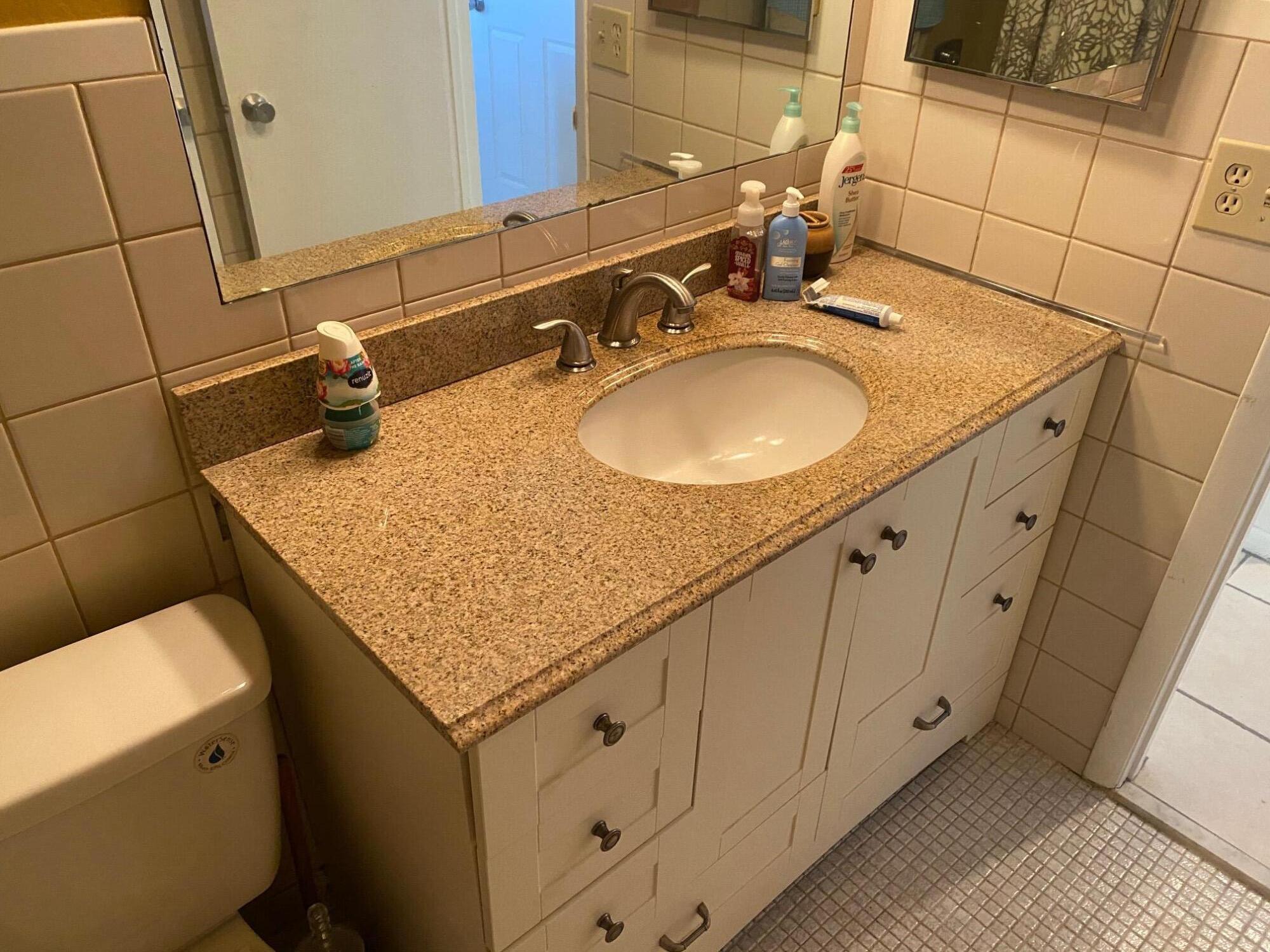 2615 Northeast 3rd Street, Unit 302 Boynton Beach, FL 33435 - Photo 13 of 14 a bathroom with a granite countertop sink and a mirror