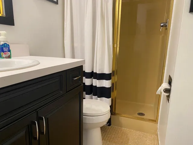a bathroom with a sink a toilet and shower