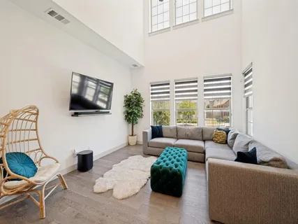 a living room with furniture a flat screen tv and a large window