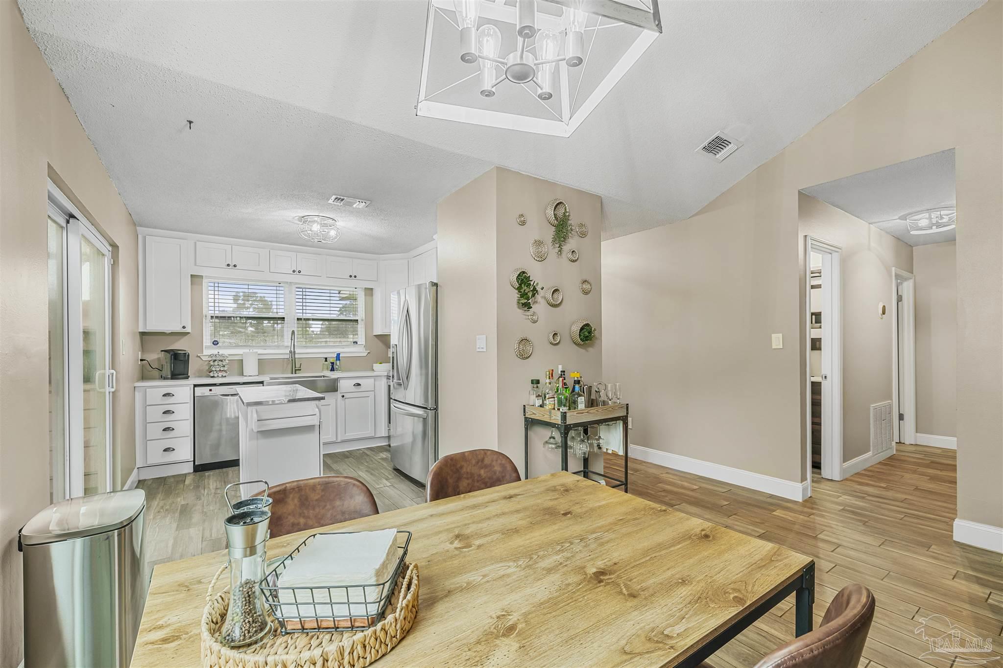 1833 Hunters Path Fort Walton Beach, FL 32547 - Photo 11 of 44 a kitchen with stainless steel appliances kitchen island granite countertop a refrigerator a stove top oven and white cabinets