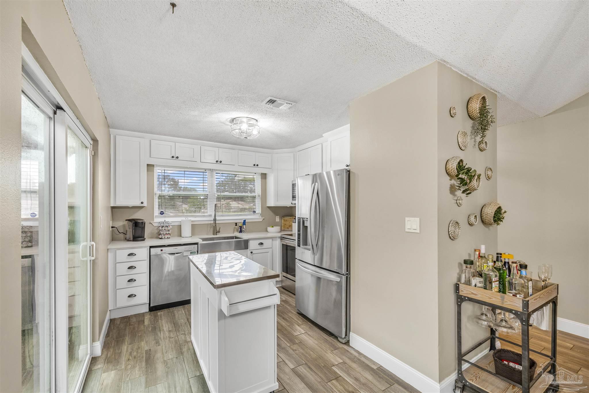 1833 Hunters Path Fort Walton Beach, FL 32547 - Photo 15 of 44 a kitchen with stainless steel appliances a refrigerator a sink a stove and white cabinets