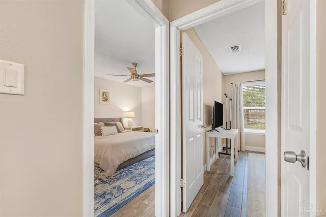 a bedroom with a bed a flat screen tv and a large window