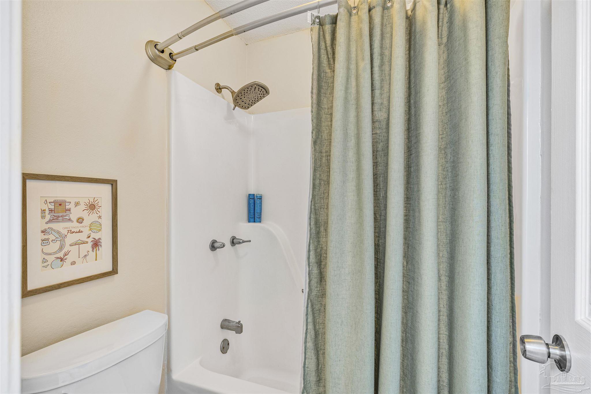 1833 Hunters Path Fort Walton Beach, FL 32547 - Photo 28 of 44 a bathroom with a shower curtain