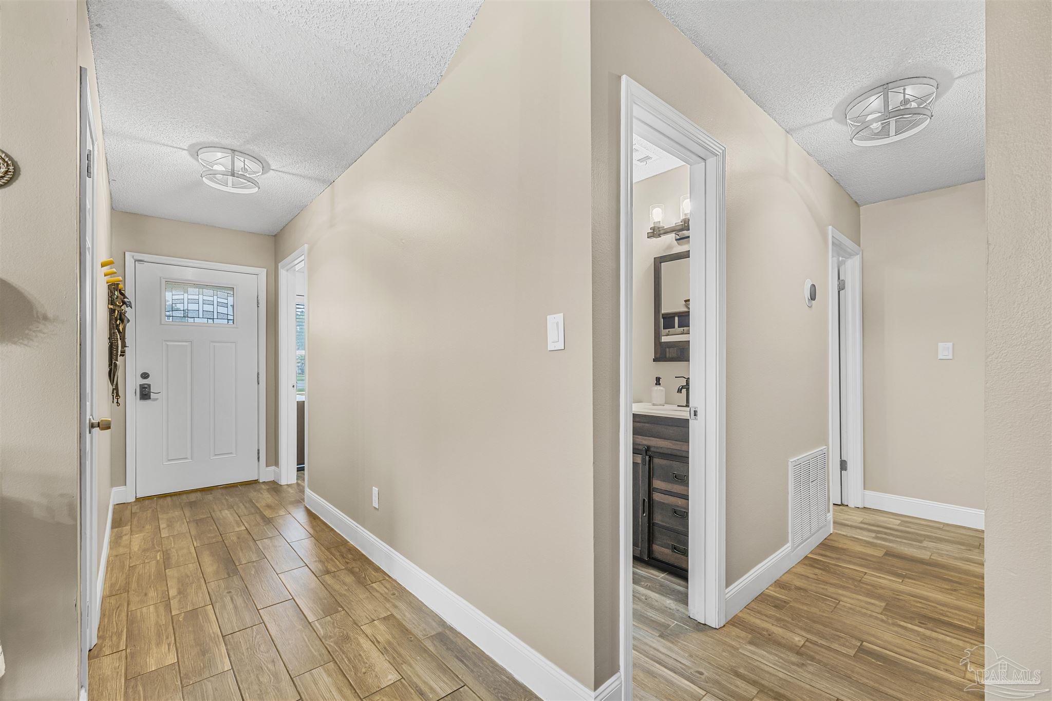 1833 Hunters Path Fort Walton Beach, FL 32547 - Photo 5 of 44 a view of a hallway with wooden floor and closet