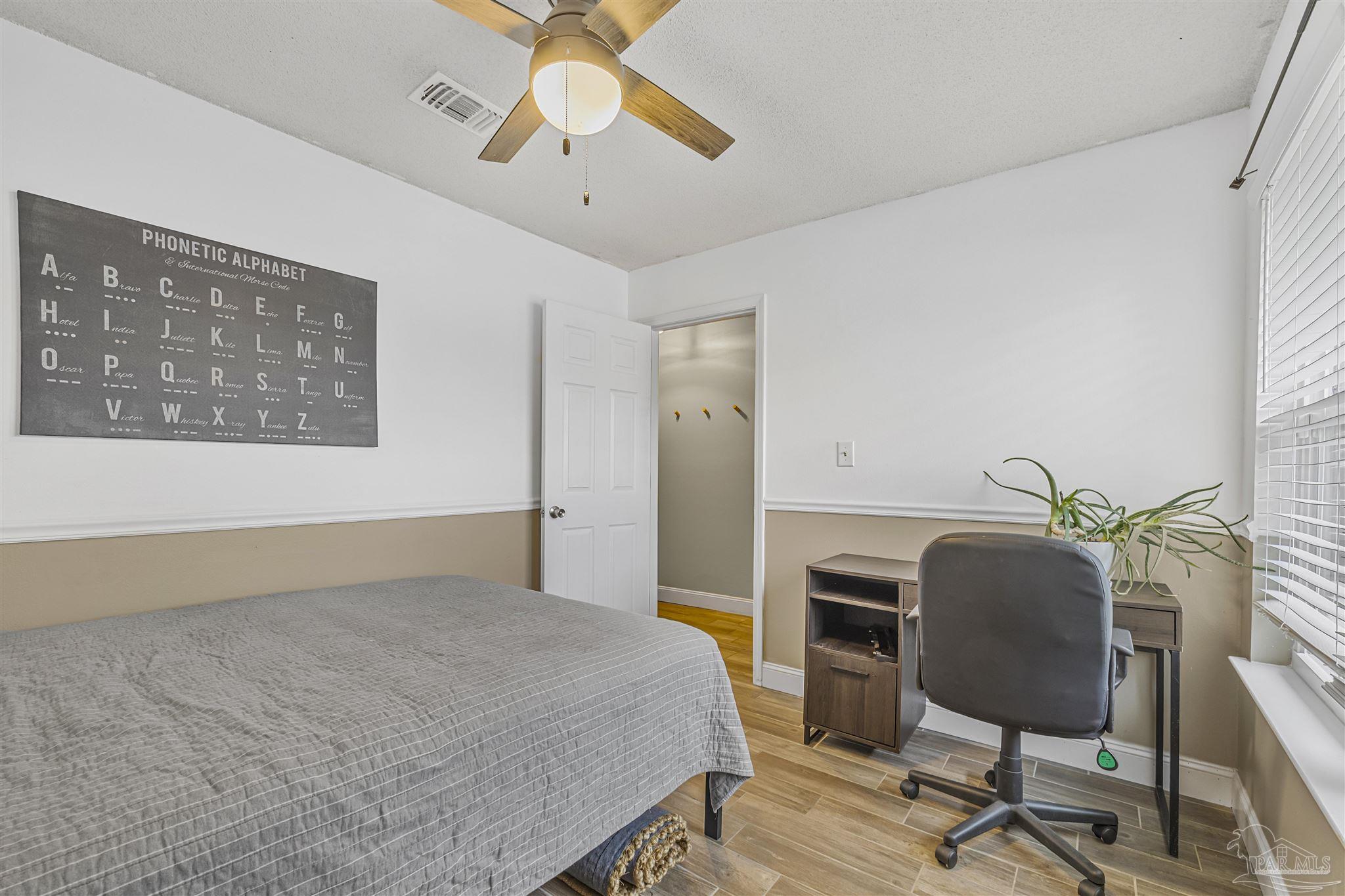 1833 Hunters Path Fort Walton Beach, FL 32547 - Photo 7 of 44 a bedroom with a bed and a chandelier