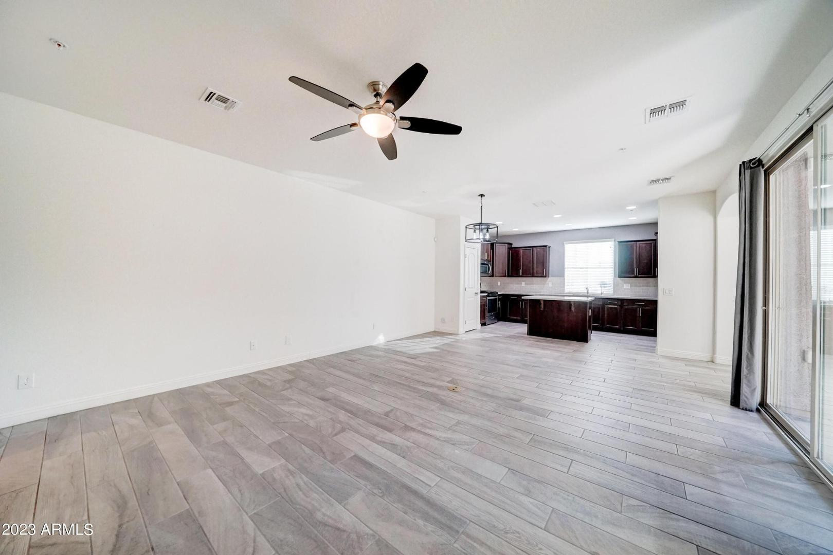 2297 North Alsap Road Buckeye, AZ 85396 - Photo 6 of 36 a view of empty room with wooden floor and window