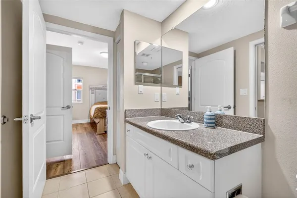 a bathroom with a granite countertop sink a toilet a mirror and shower
