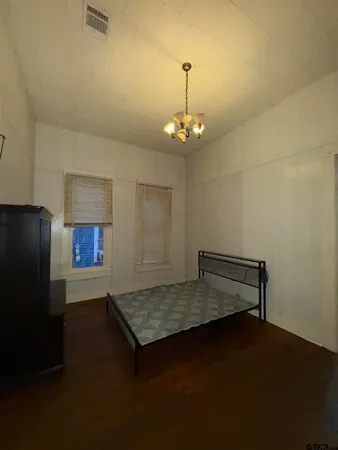 wooden floor in an empty room with a kitchen