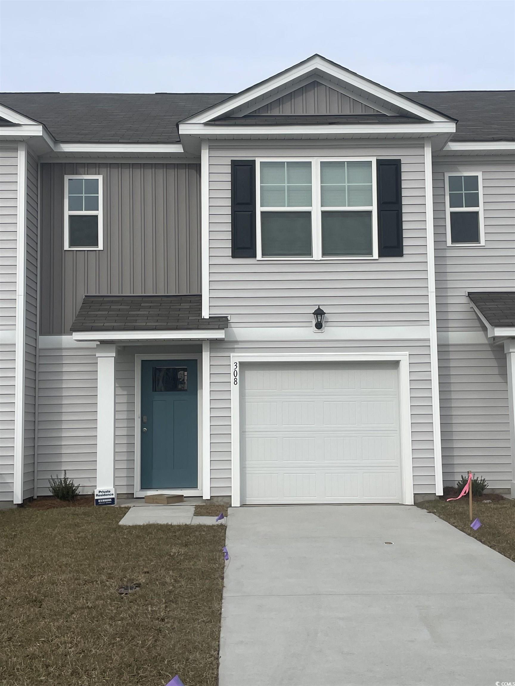 308 Bayou Loop, Unit LOT 61 Surfside Beach, SC 29575 - Photo 1 of 17 View of front of house with board and batten siding, a garage, a shingled roof, and concrete driveway