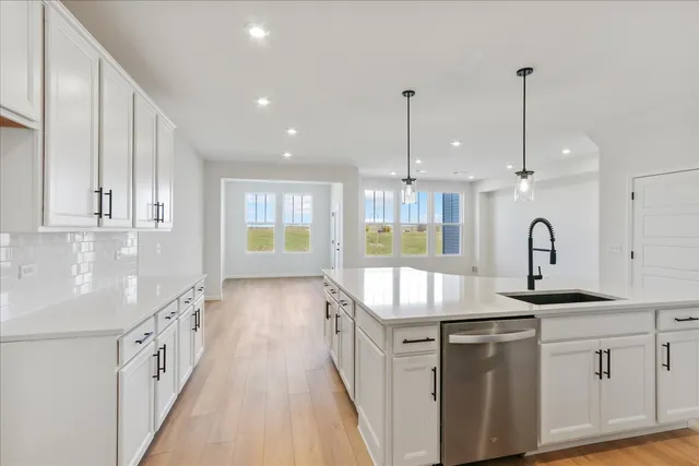 a kitchen with granite countertop a sink a counter top space and stainless steel appliances