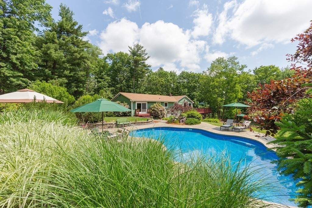 27 Algonquin Road Canton, MA 02021 - Photo 1 of 42 a view of a swimming pool with lawn chairs under an umbrella
