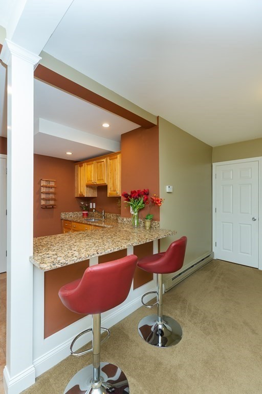 27 Algonquin Road Canton, MA 02021 - Photo 32 of 42 a kitchen with stainless steel appliances kitchen island granite countertop a table and chairs in it