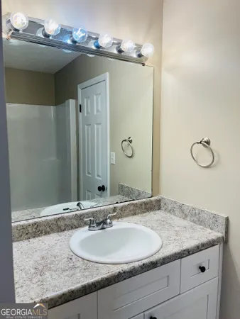 a bathroom with a granite countertop sink and a mirror