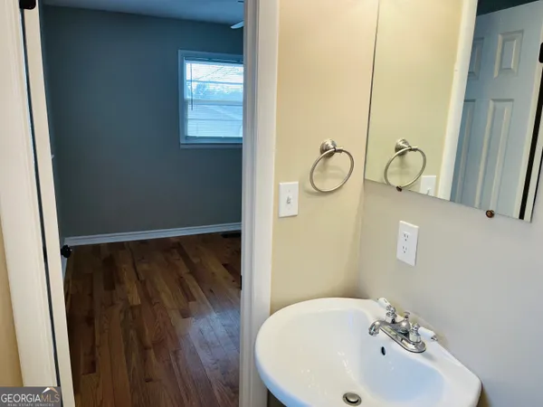 a bathroom with a sink and mirror with bathtub