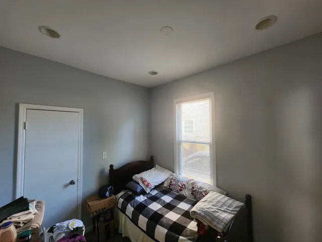 a bedroom with a bed and a window