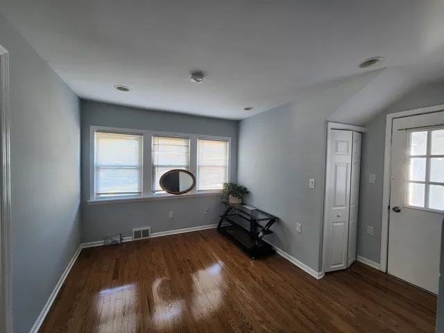 a view of a room with wooden floor and windows