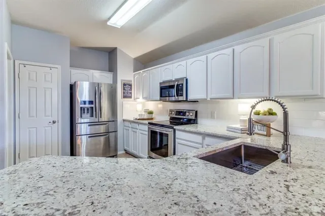 a kitchen with stainless steel appliances granite countertop a refrigerator stove and microwave