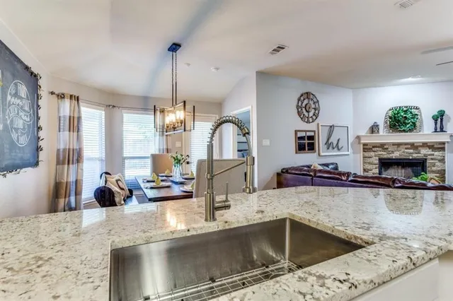 a kitchen with a stove a faucet a chandelier and living room view