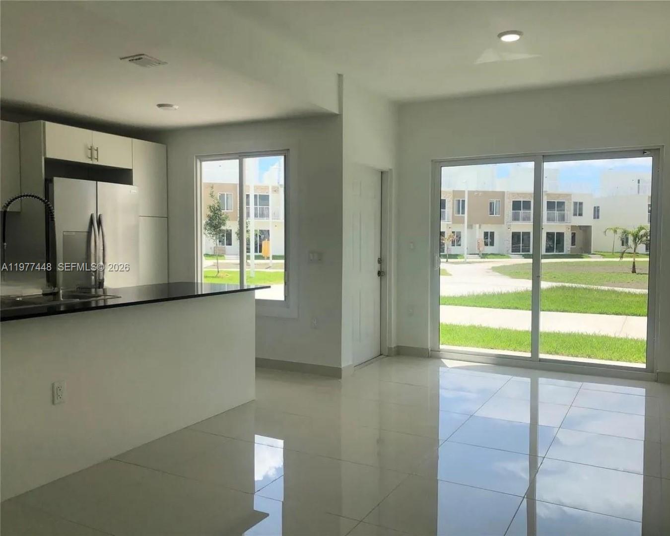 25869 Southwest 139th Path Homestead, FL 33032 - Photo 13 of 17 a view of an empty room with window
