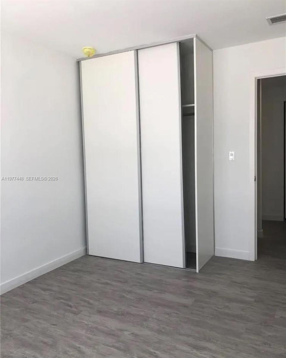 25869 Southwest 139th Path Homestead, FL 33032 - Photo 8 of 17 a view of an empty room with wooden floor