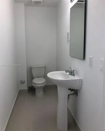 a bathroom with a sink toilet and mirror