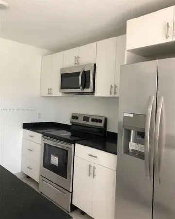 a kitchen with stainless steel appliances white cabinets and a stove