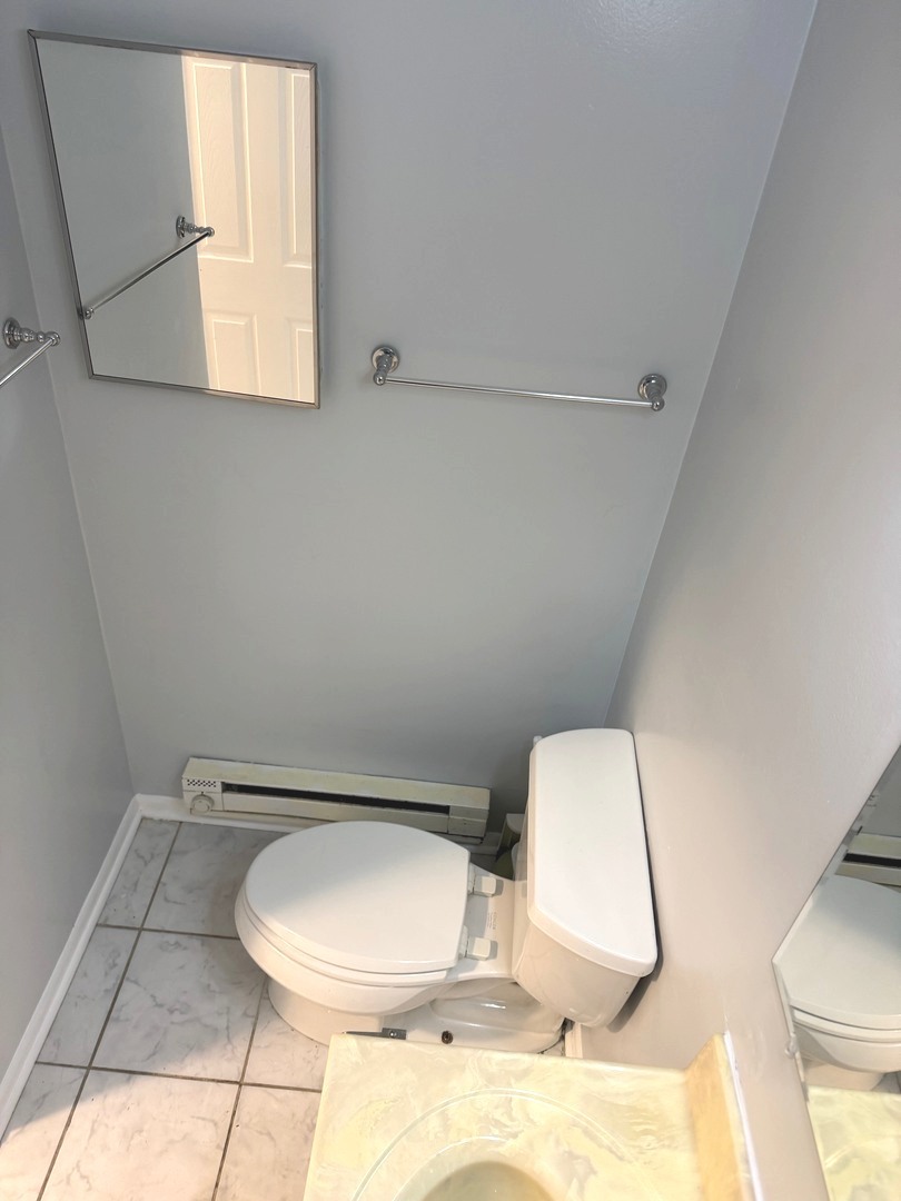 1110 18th Street, Unit 1E Broadview, IL 60155 - Photo 16 of 20 a bathroom with a toilet mirror and vanity