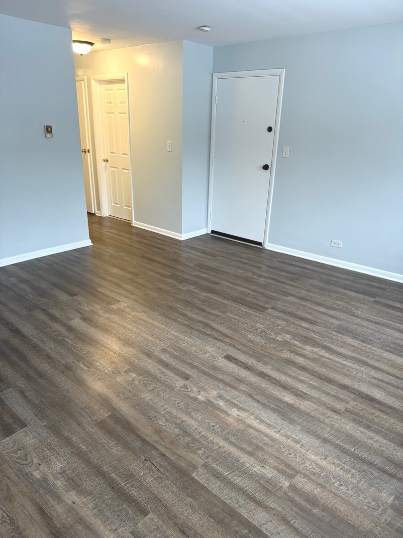1110 18th Street, Unit 1E Broadview, IL 60155 - Photo 3 of 20 a view of an empty room with wooden floor