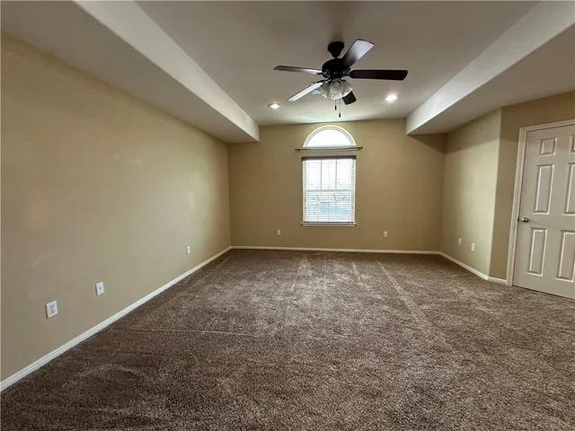 en empty room with windows and ceiling fan