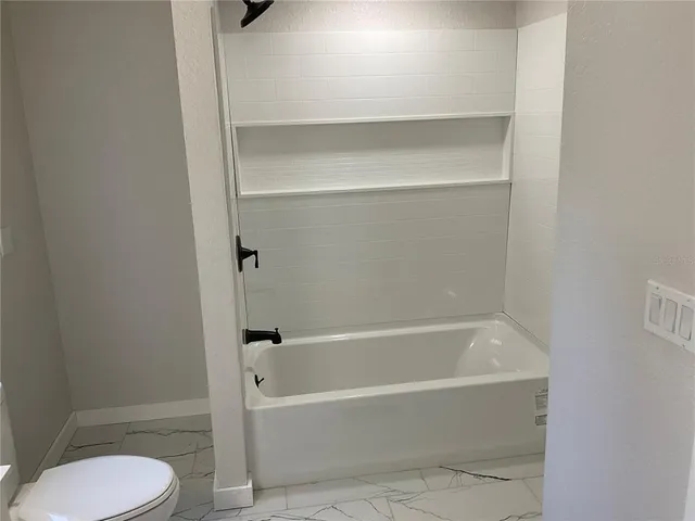 a white bath tub sitting next to a toilet