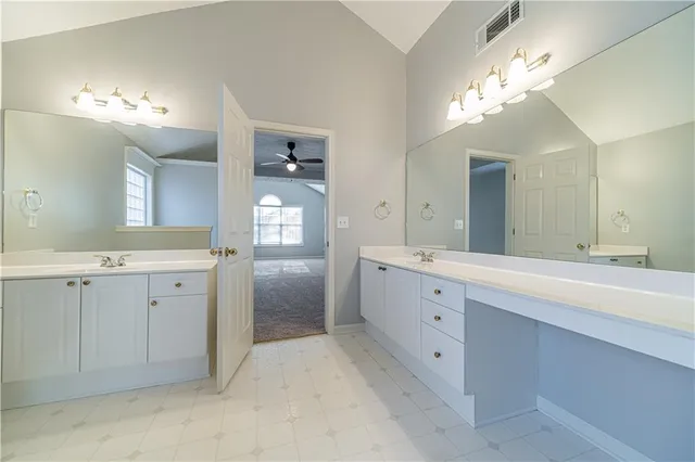 a spacious bathroom with a double vanity sink mirror and bathtub