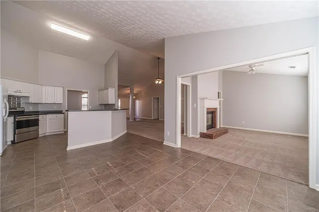 a view of a kitchen with refrigerator and chairs
