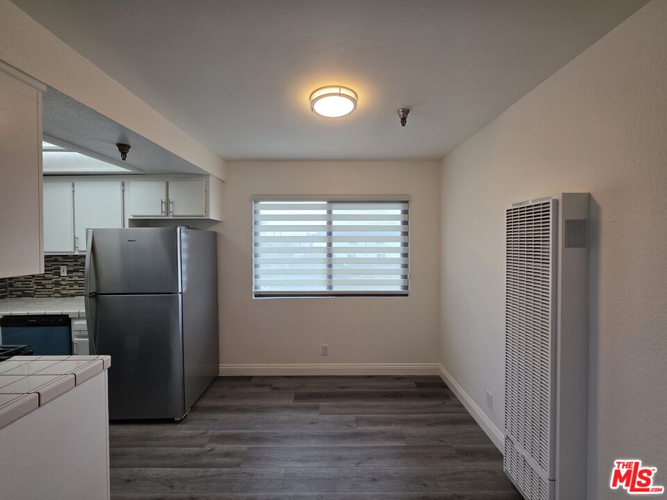 3204 139th Street, Unit 6 Hawthorne, CA 90250 - Photo 16 of 37 a view of a kitchen with a refrigerator wooden floor and a window