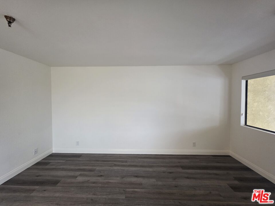 3204 139th Street, Unit 6 Hawthorne, CA 90250 - Photo 8 of 37 a view of an empty room with wooden floor and a window