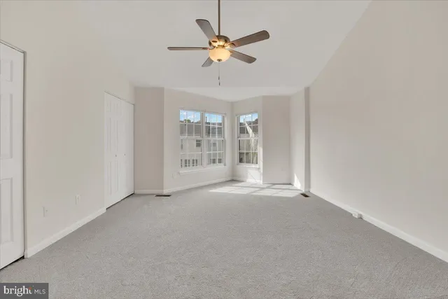 a view of an empty room with a ceiling fan