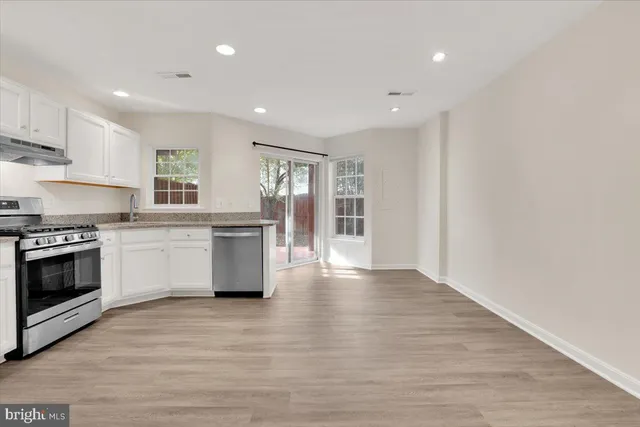 a kitchen with stainless steel appliances granite countertop a stove top oven and sink
