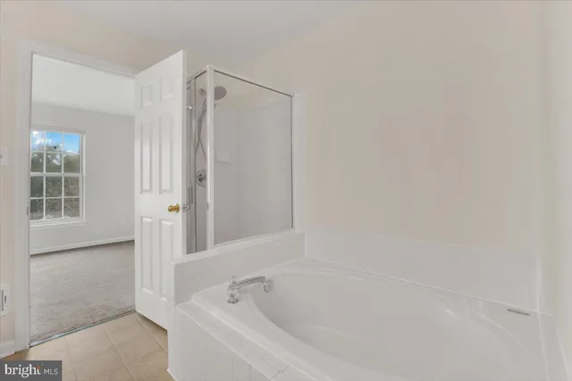 a white bath tub sitting next to a shower