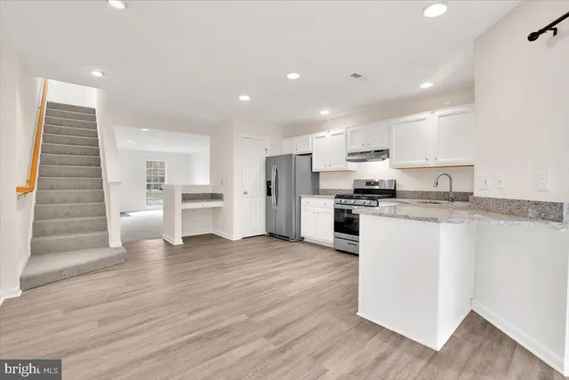 a view of kitchen with wooden floor and electronic appliances