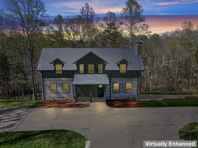 a front view of a house with a yard and tree s