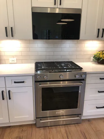 a stove top oven sitting inside of a kitchen