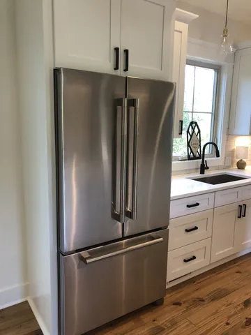 a close view of a refrigerator in kitchen and window