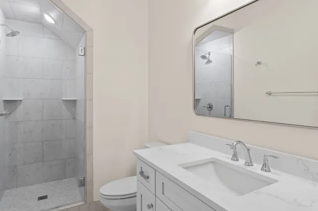 a bathroom with a sink a toilet and shower