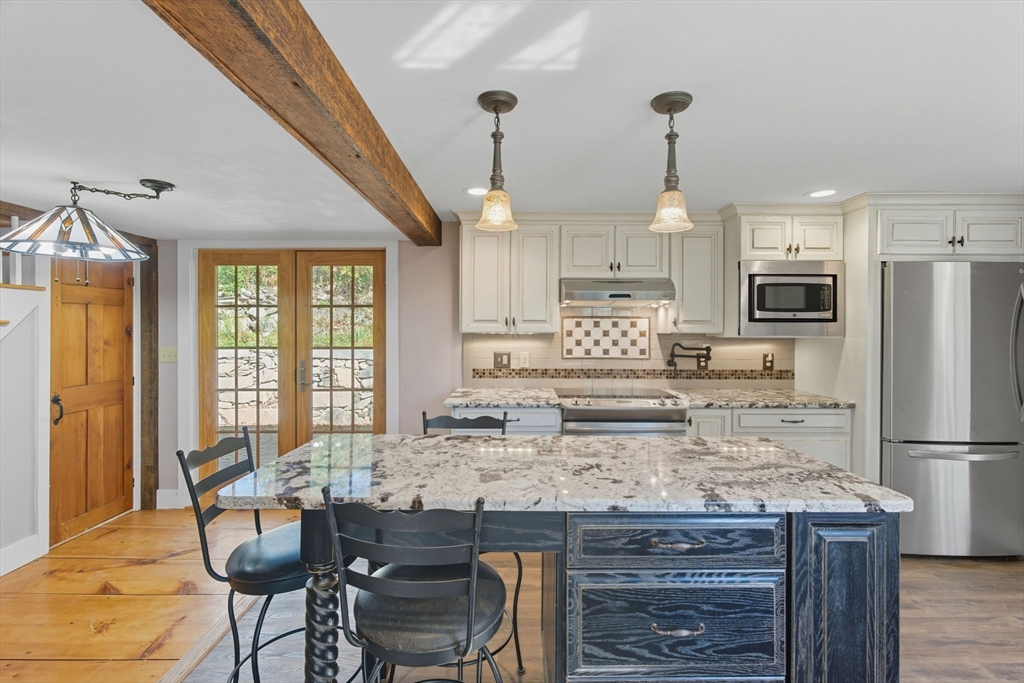 227 Boston Road Groton, MA 01450 - Photo 14 of 42 a kitchen with kitchen island granite countertop a sink cabinets and refrigerator