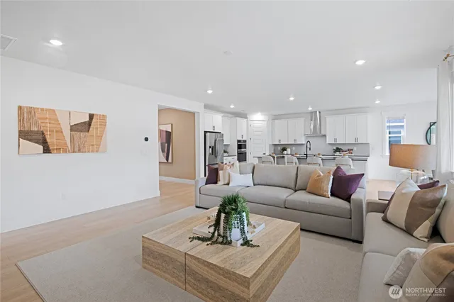 a living room with furniture white walls and kitchen view